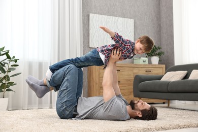 Photo of Happy dad and son having fun together at home