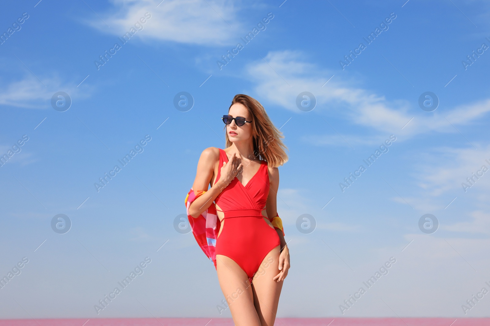 Photo of Beautiful woman in swimsuit posing against blue sky on sunny day