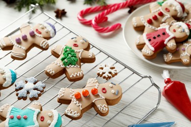 Making homemade Christmas cookies. Gingerbread people and festive decor on white wooden table