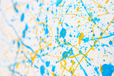 Photo of Colorful paint splashes on white canvas as background. Art and creativity