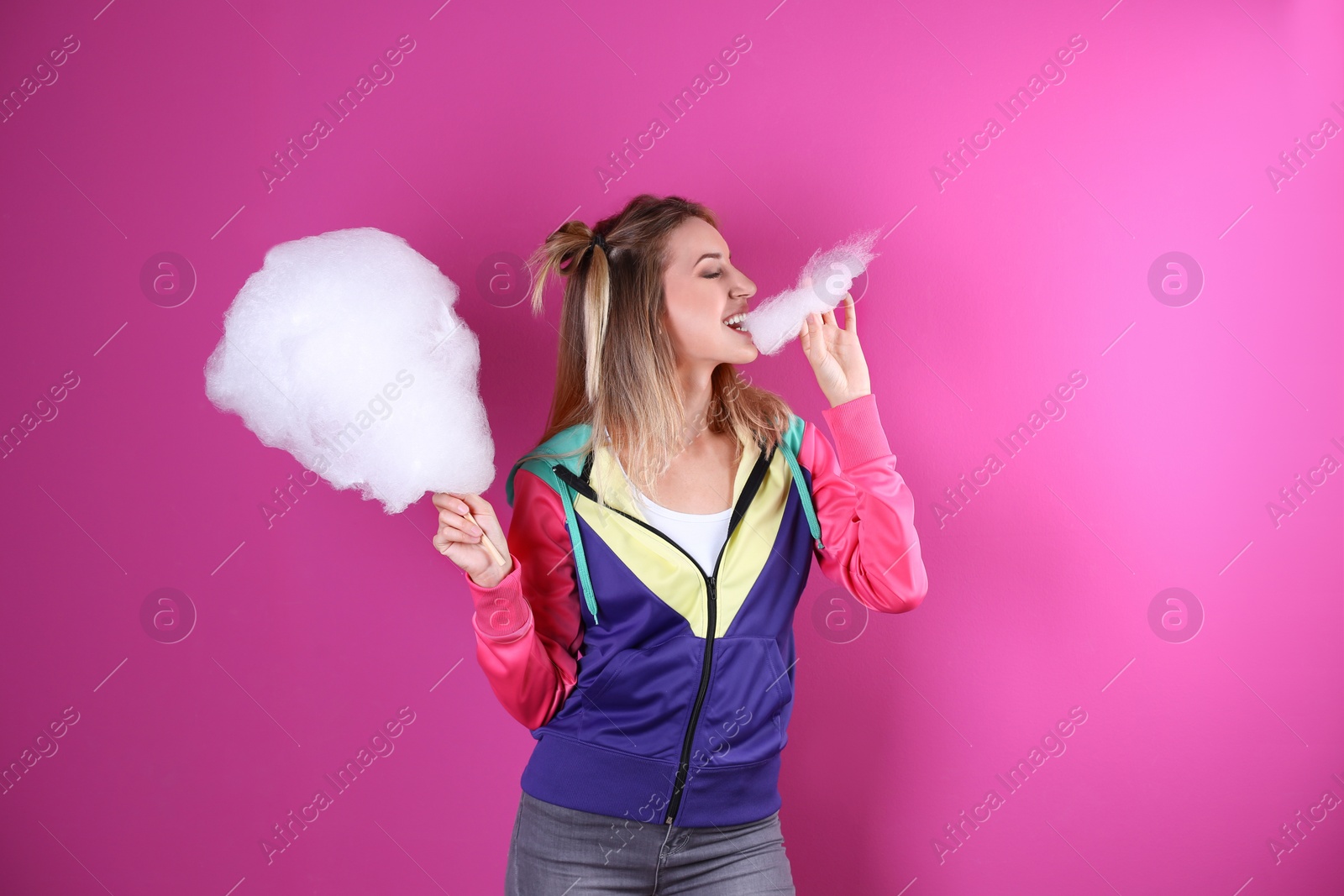 Photo of Young pretty woman with cotton candy on colorful background