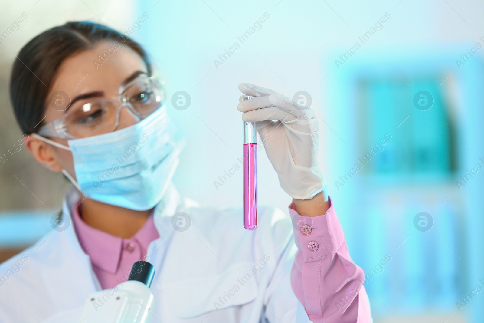 Photo of Young scientist holding test tube with sample on blurred background. Laboratory analysis