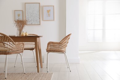 Dining room interior with wooden table and wicker chairs