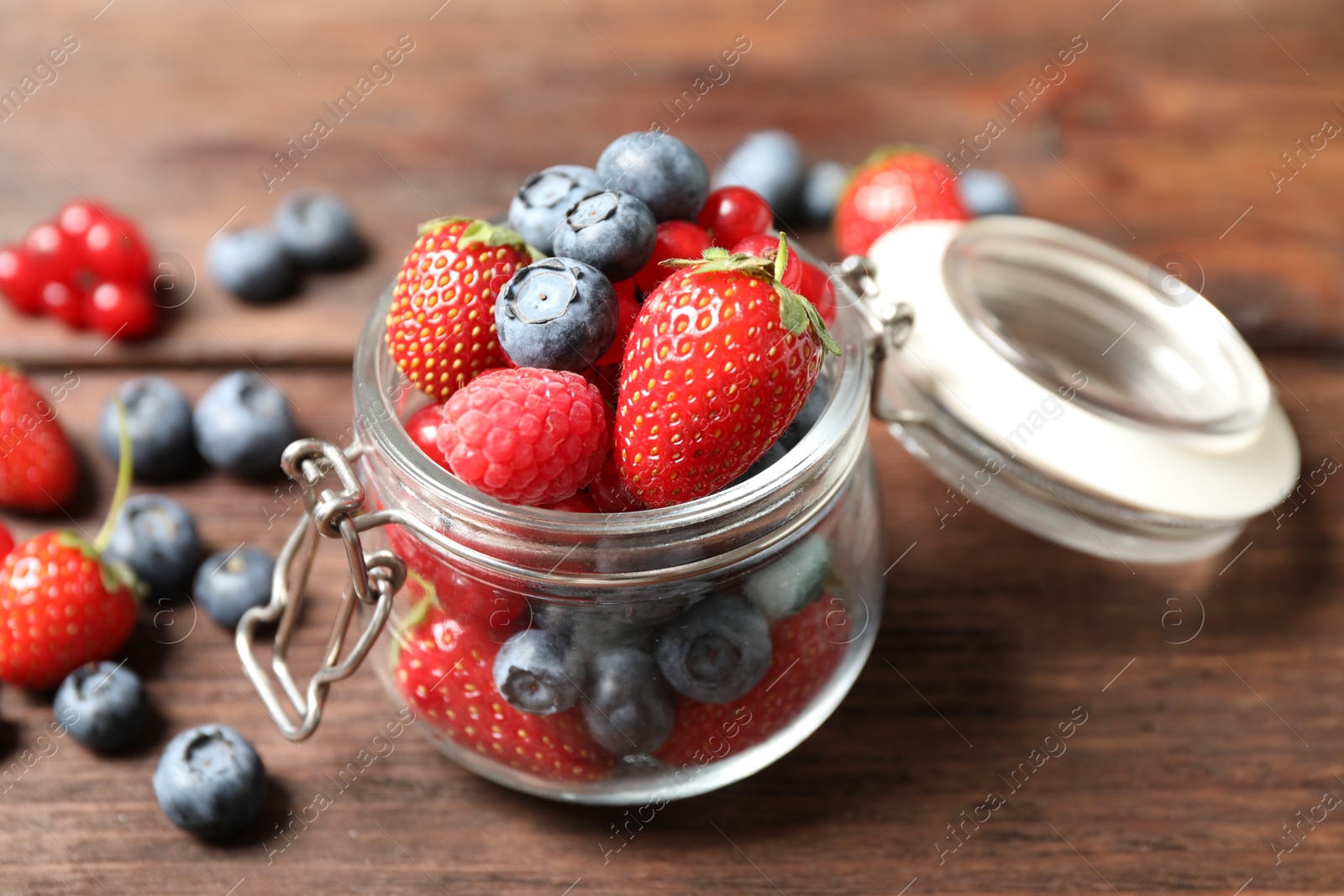 Photo of Mix of ripe berries on wooden table, closeup