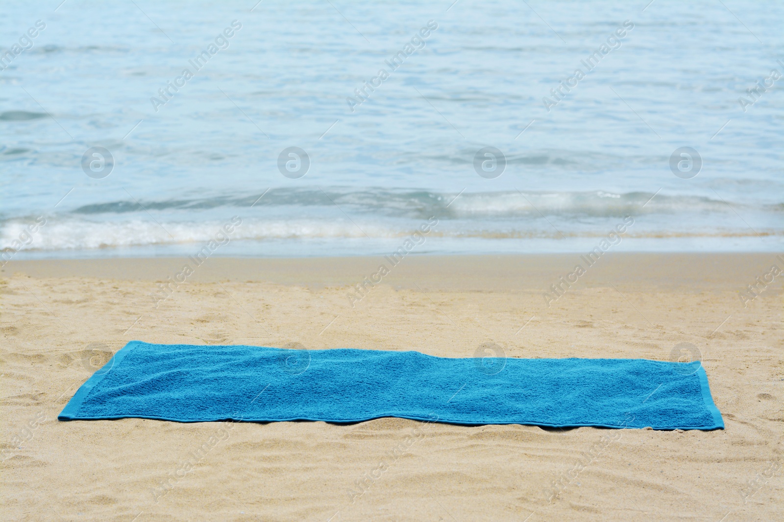 Photo of Blue towel on sandy beach near sea