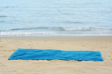 Photo of Blue towel on sandy beach near sea