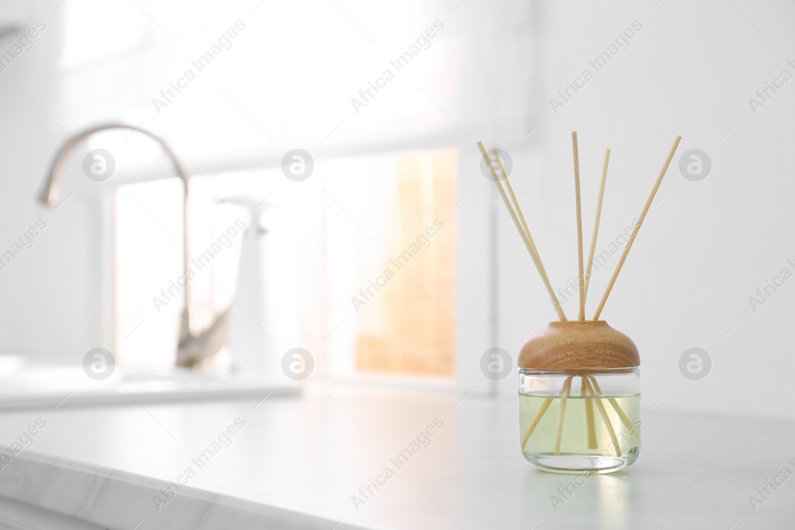 Photo of Aromatic reed air freshener on light table indoors. Space for text