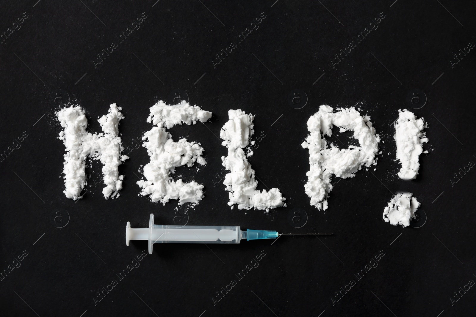 Photo of Text Help written with cocaine powder and syringe on black background, top view