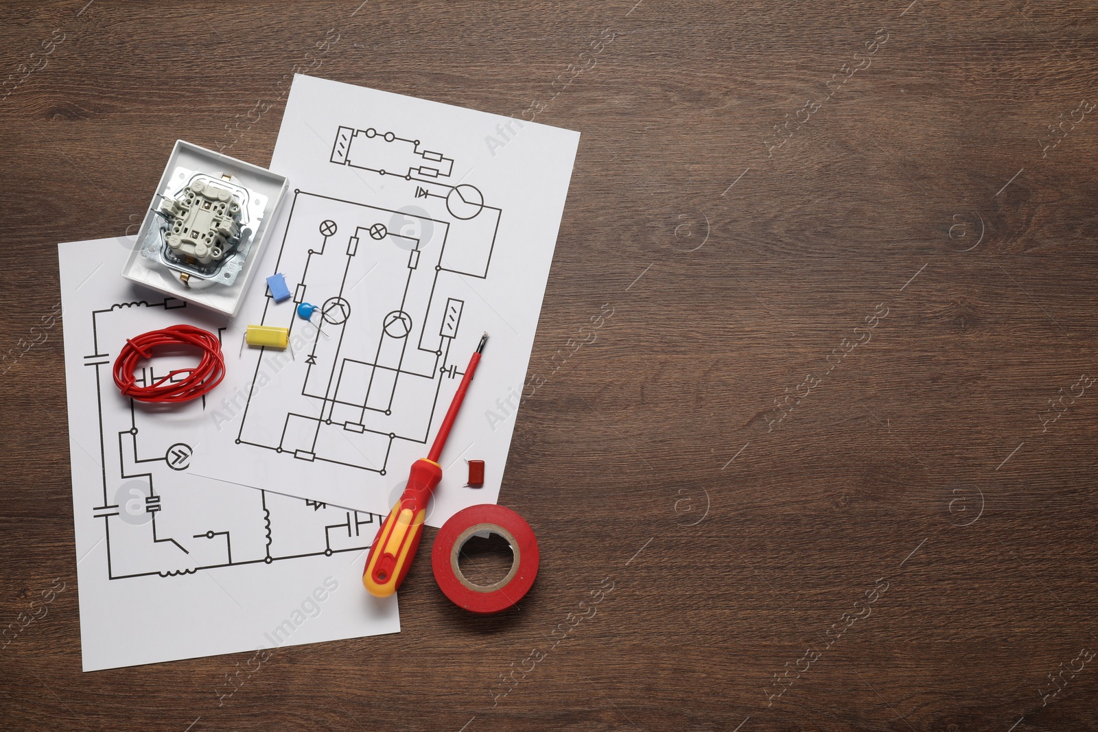 Photo of Wiring diagrams, wires and disassembled light switch on wooden table, flat lay. Space for text