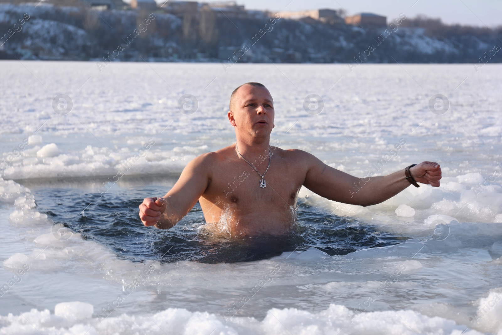 Photo of MYKOLAIV, UKRAINE - JANUARY 06, 2021: Man immersing in icy water on winter day