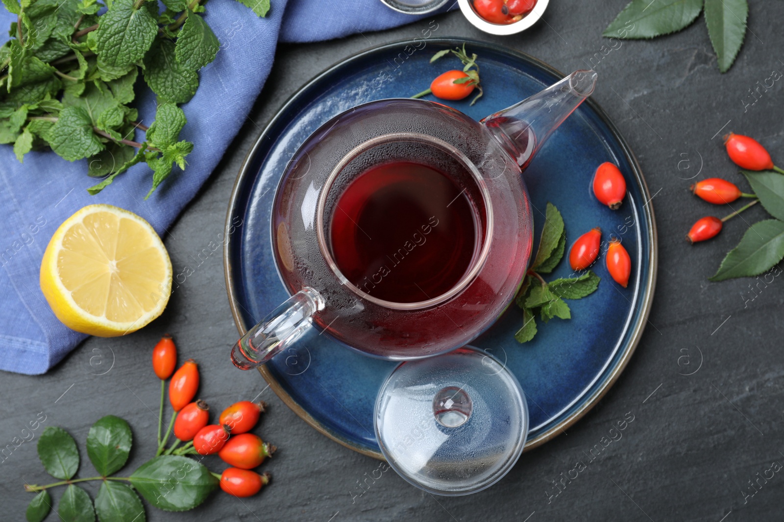 Photo of Flat lay composition with aromatic rose hip tea on black table