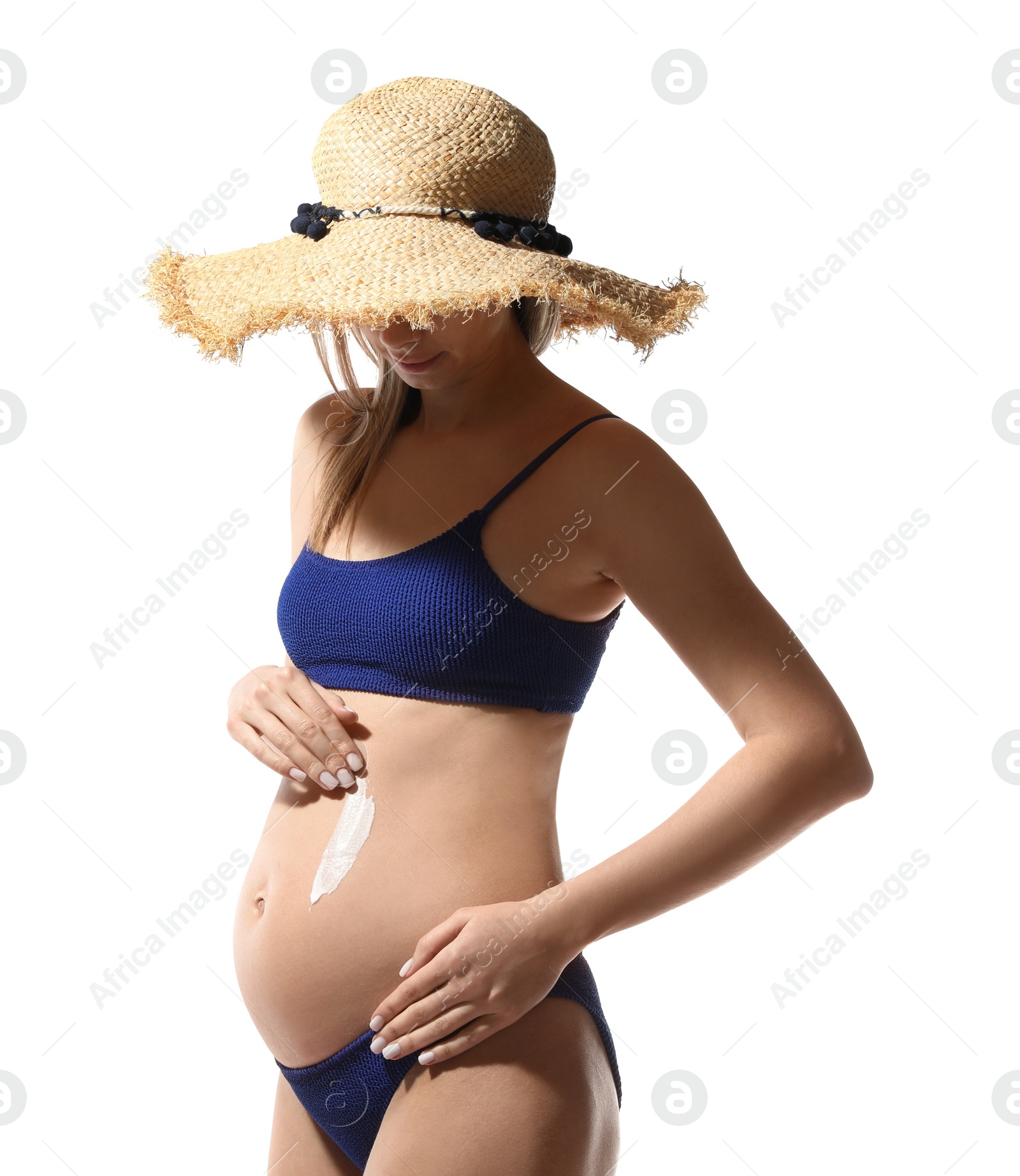 Photo of Pregnant woman applying sun protection cream on her belly against white background