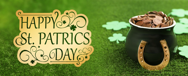 Image of Pot of gold coins, horseshoe and clover leaves on green grass. St. Patrick's Day celebration