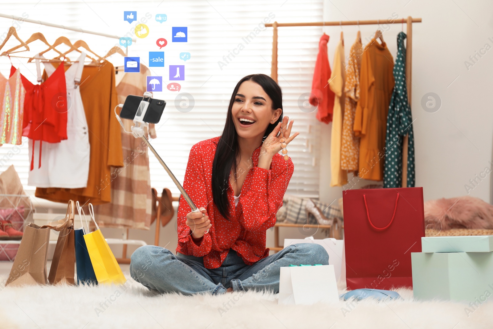 Image of Fashion blogger recording video with smartphone in room