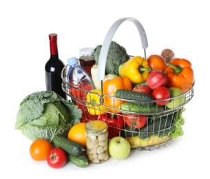 Photo of Shopping basket and grocery products on white background