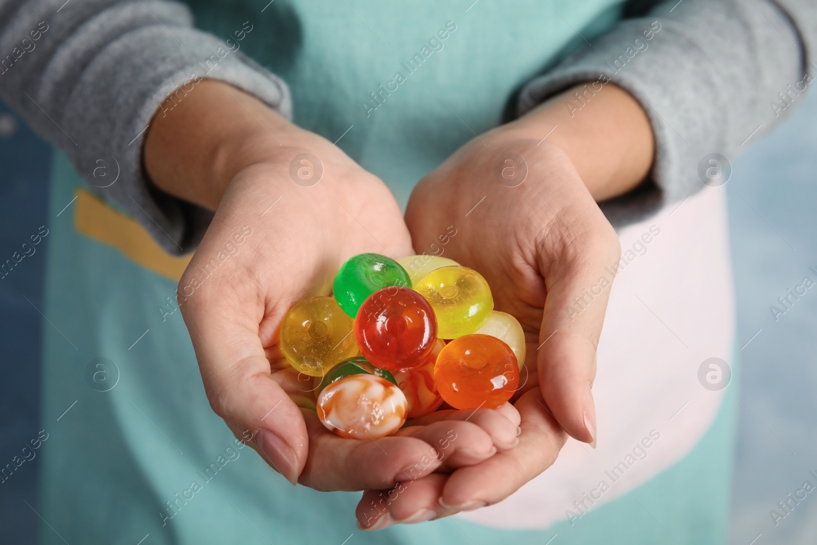 Photo of Woman holding many colorful sweet candies, closeup