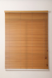 Photo of Modern window with closed wooden blinds indoors