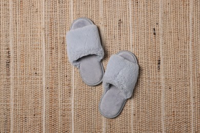 Soft fluffy grey slippers on carpet, top view