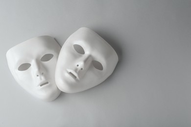 Photo of White theatre masks on grey background, flat lay. Space for text