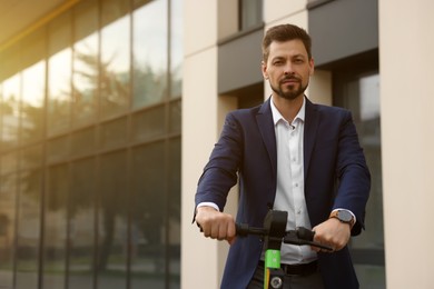 Photo of Businessman with modern kick scooter on city street, space for text