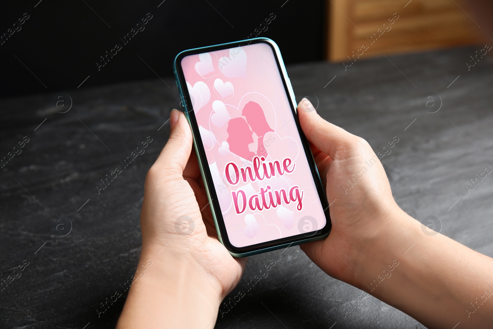 Image of Woman visiting dating site via smartphone at table, closeup