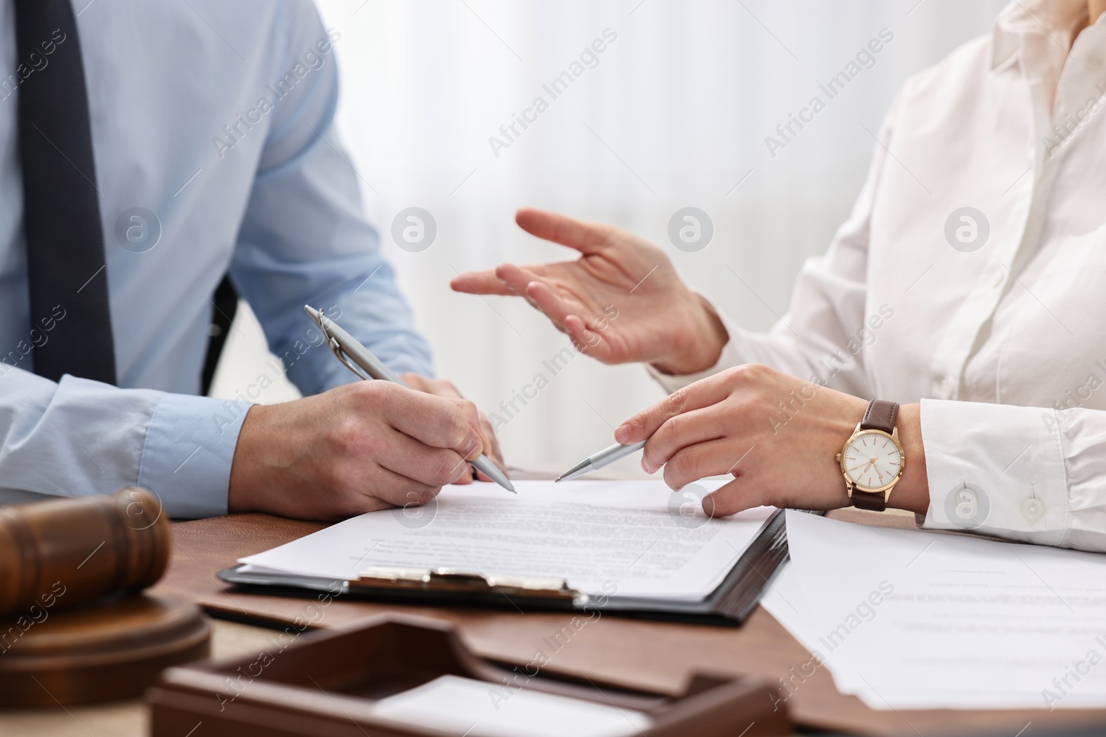 Photo of Lawyers working with documents at table in office, closeup