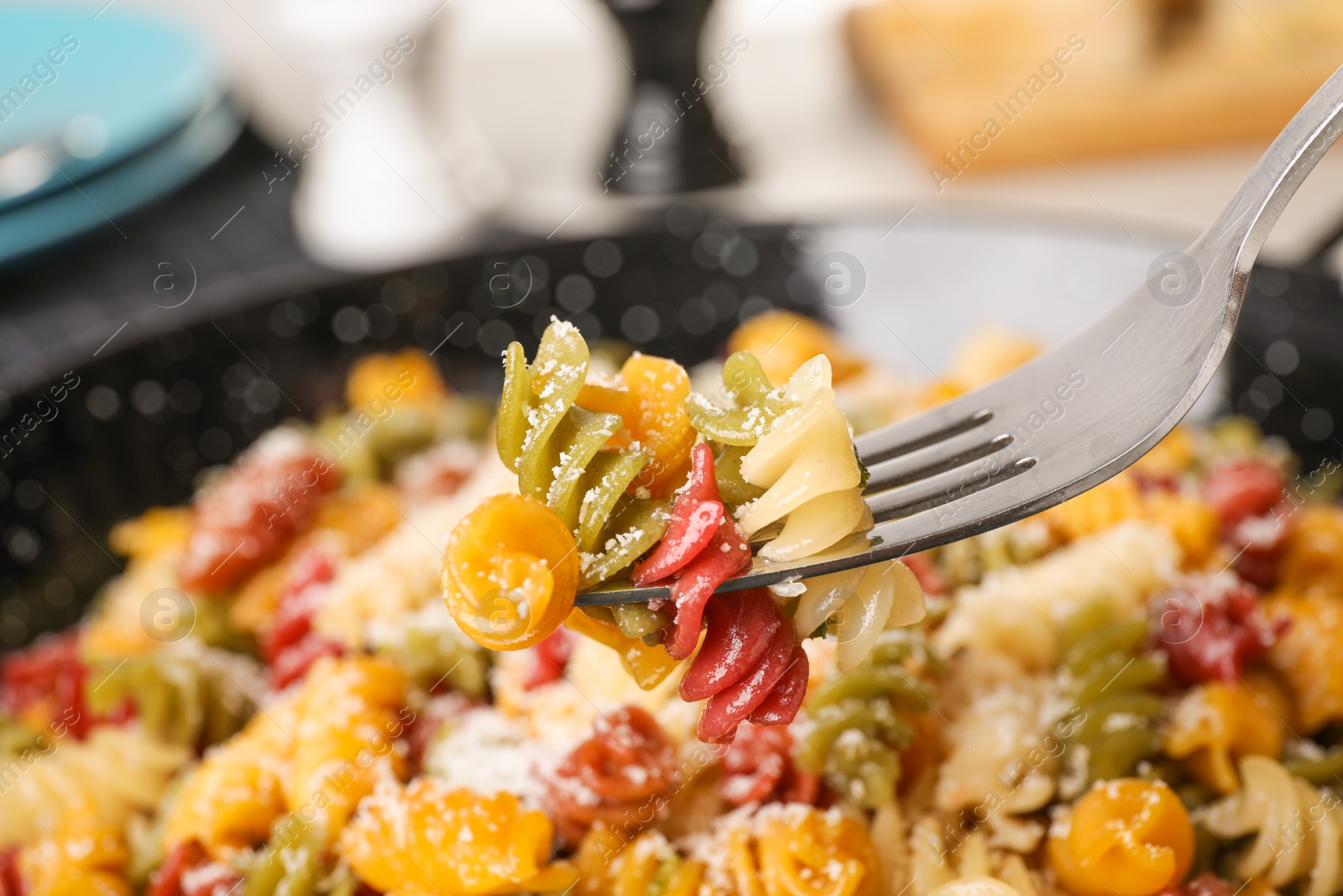 Photo of Colorful pasta with cheese on fork, closeup