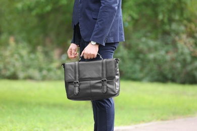 Photo of Businessman with black briefcase in hand outdoors