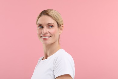 Woman with clean teeth smiling on pink background, space for text