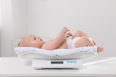 Cute little baby lying on scales in clinic