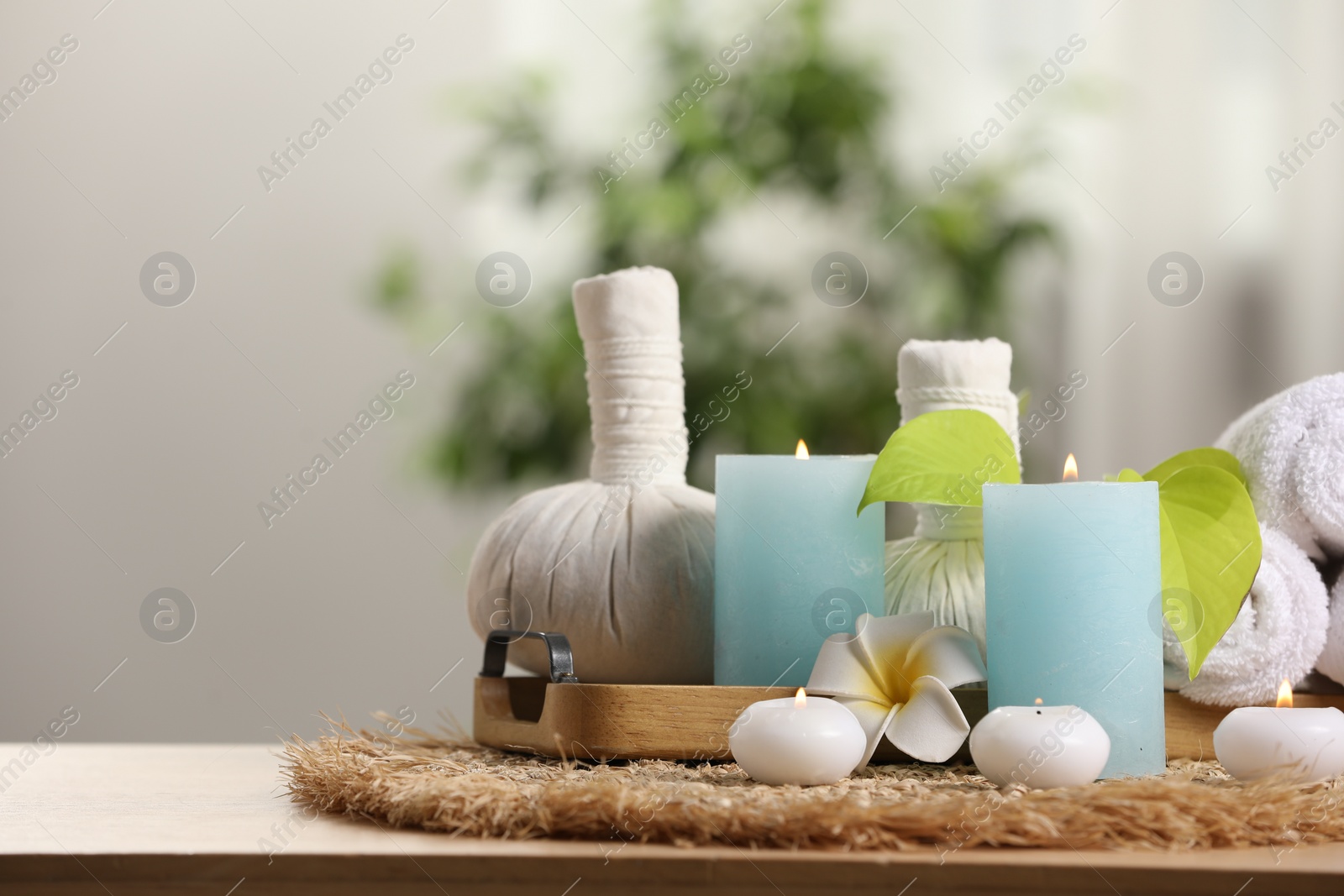 Photo of Composition with different spa products and burning candles on wooden table indoors, space for text