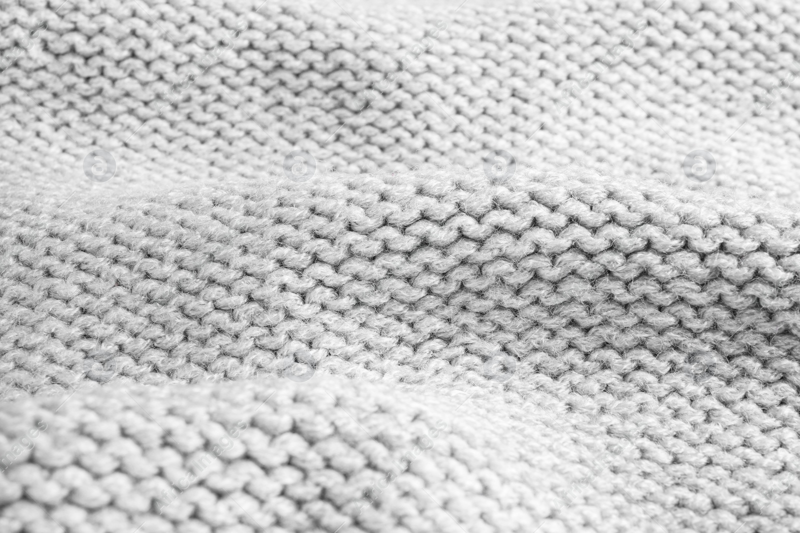 Photo of Grey knitted sweater as background, closeup view