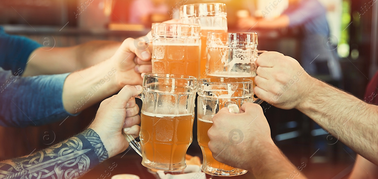 Image of Group of friends toasting with beer in pub, closeup. Banner design