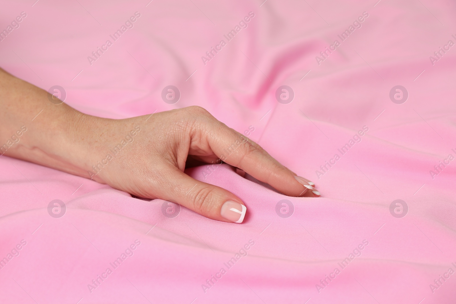 Photo of Woman touching delicate pink fabric, closeup view