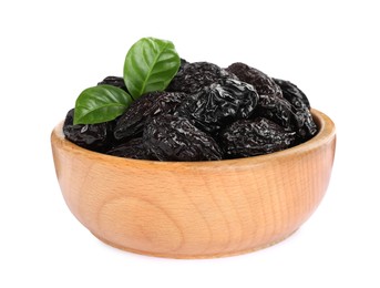 Photo of Wooden bowl with sweet dried prunes and green leaves isolated on white