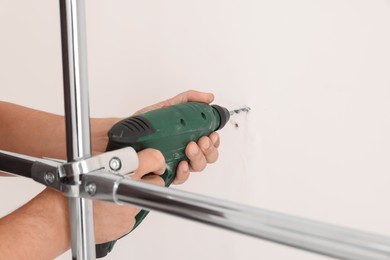 Worker installing new metal pipes with electric drill, closeup