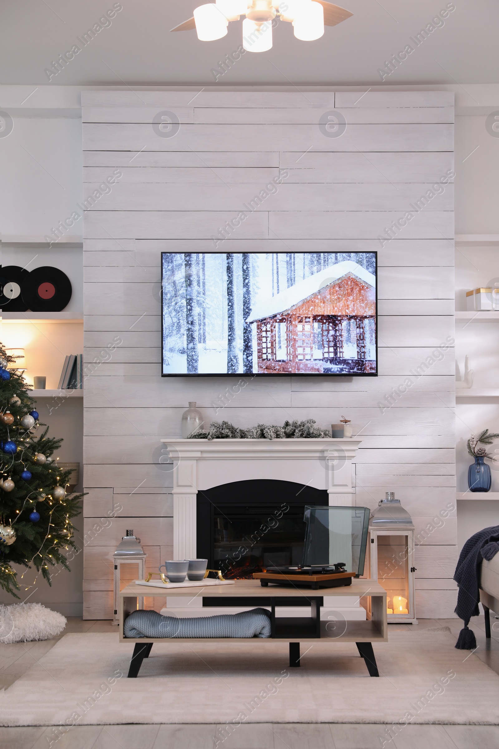 Photo of Stylish living room interior with modern TV, fireplace and Christmas tree