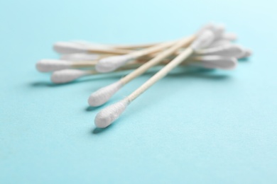 Pile of cotton swabs and space for text on color background