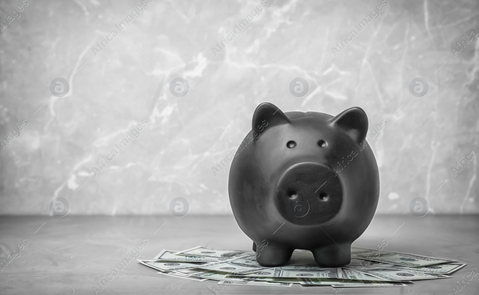 Photo of Black piggy bank and money on table