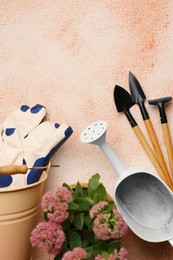 Photo of Flat lay composition with watering can and gardening tools on color textured background. Space for text