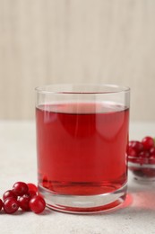 Photo of Tasty refreshing cranberry juice and fresh berries on light table