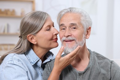 Photo of Senior woman kissing her beloved man indoors