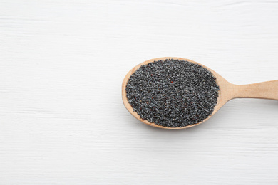Photo of Poppy seeds in spoon on white wooden table, top view. Space for text