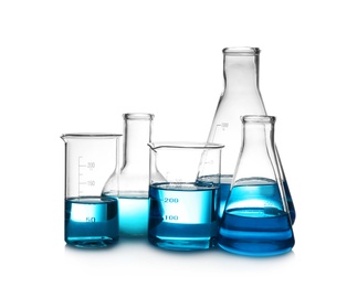 Laboratory glassware with liquid on table against white background. Chemical analysis