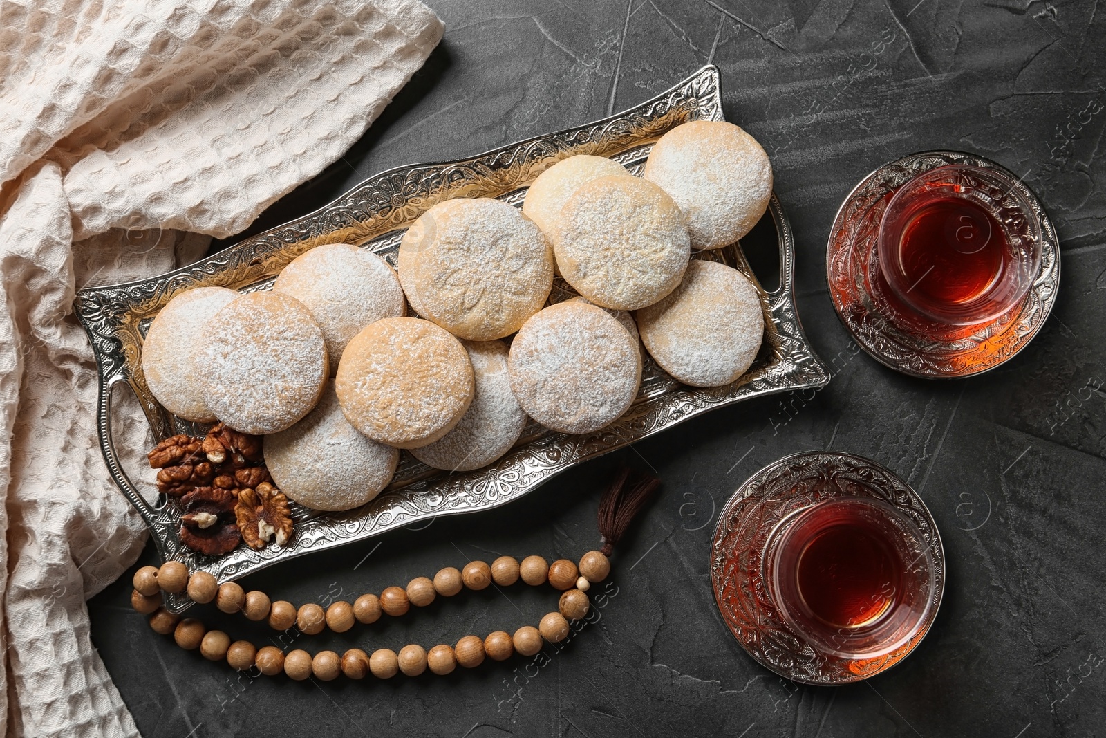 Photo of Flat lay composition with tray of traditional cookies for Islamic holidays on table. Eid Mubarak