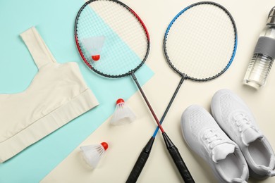 Photo of Flat lay composition with badminton rackets and shuttlecocks on color background