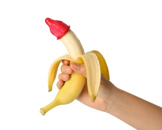 Woman holding banana in condom on white background, closeup. Safe sex concept