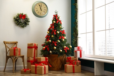Decorated Christmas tree with gifts. Festive interior