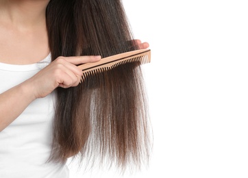 Young woman with wooden hair comb on white background, closeup