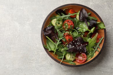 Photo of Tasty fresh vegetarian salad on grey table, top view. Space for text